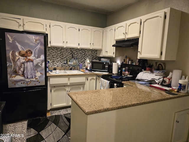 kitchen with a peninsula, a sink, black appliances, white cabinets, and under cabinet range hood