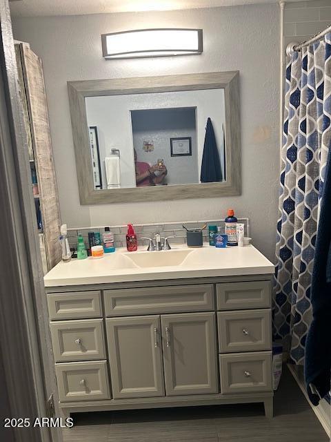 bathroom with curtained shower and vanity