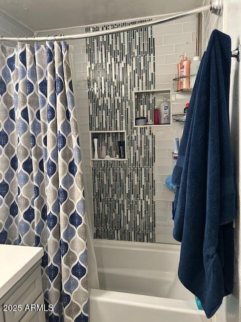 bathroom with shower / bath combination with curtain and vanity