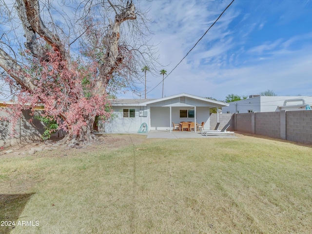 rear view of property with a yard and a patio