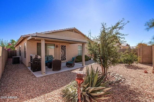 rear view of house featuring central AC, a patio area, a fenced backyard, and stucco siding