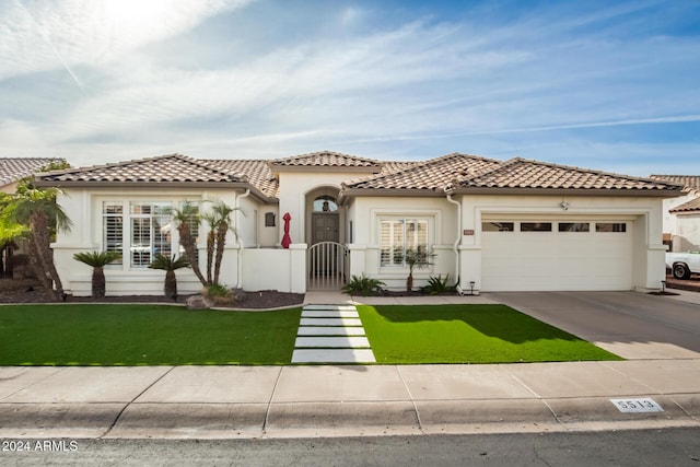 mediterranean / spanish home with a front yard and a garage