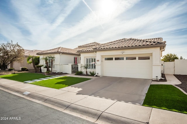 mediterranean / spanish-style house with a garage and a front lawn