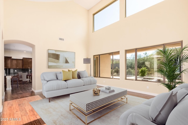 26796 N 86th Ln, Peoria, AZ 85383 - living room featuring wood finished floors, plenty of natural light, arched walkways, and visible vents