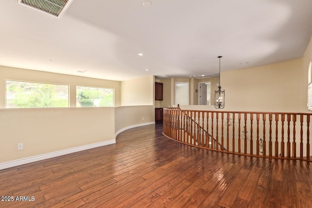 26796 N 86th Ln, Peoria, AZ 85383 - empty room with wood-type flooring, a notable chandelier, baseboards, and visible vents