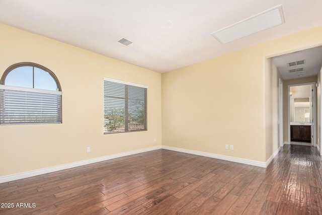 26796 N 86th Ln, Peoria, AZ 85383 - empty room with a wealth of natural light, dark wood-style floors, baseboards, and visible vents