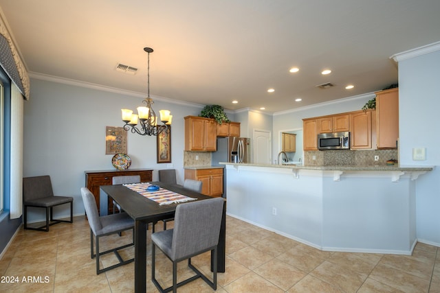 tiled dining area featuring crown molding, sink, and an inviting chandelier