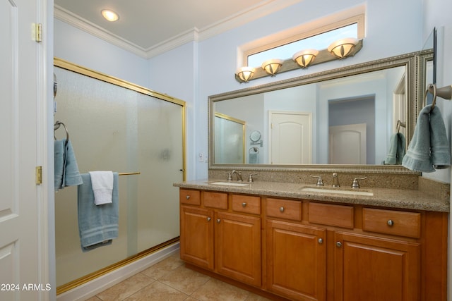 bathroom featuring vanity, tile patterned flooring, a shower with door, and ornamental molding