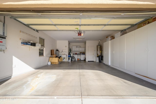 garage with gas water heater and a garage door opener