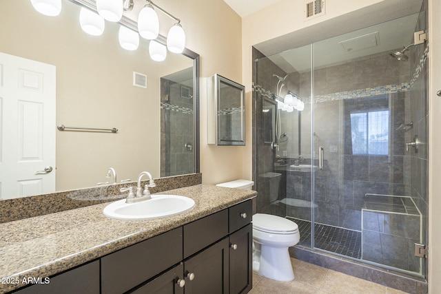 5345 E Van Buren St Unit 305, Phoenix, AZ 85008 - bathroom with tile patterned floors, a stall shower, vanity, and toilet