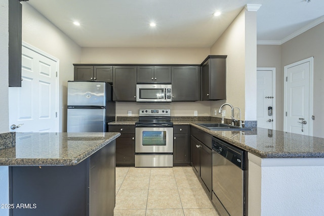 5345 E Van Buren St Unit 305, Phoenix, AZ 85008 - kitchen with stainless steel appliances, a sink, a peninsula, dark stone counters, and light tile patterned flooring