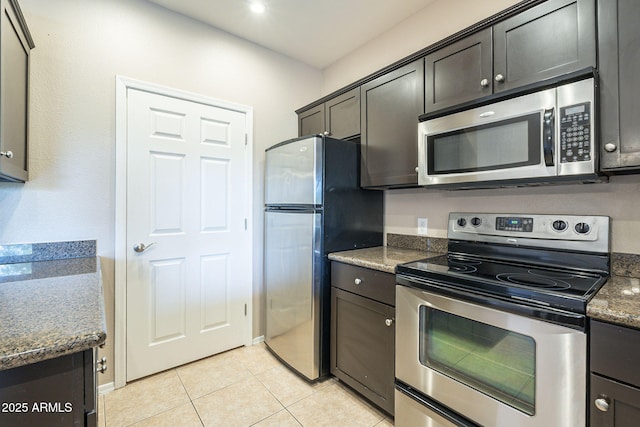 5345 E Van Buren St Unit 305, Phoenix, AZ 85008 - kitchen with stainless steel appliances, light tile patterned flooring, and dark stone countertops