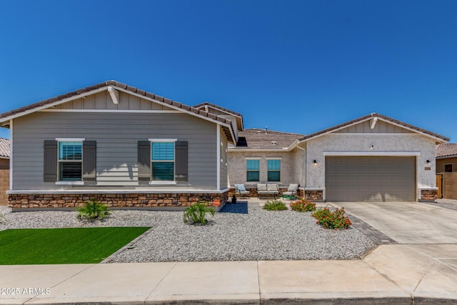 5314 N 182nd Ln, Litchfield Park, AZ 85340 - view of front of property featuring driveway, an attached garage, stone siding, and outdoor lounge area