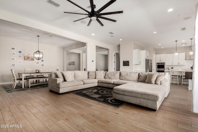 5314 N 182nd Ln, Litchfield Park, AZ 85340 - living room with ceiling fan, light wood-style floors, a chandelier, and recessed lighting