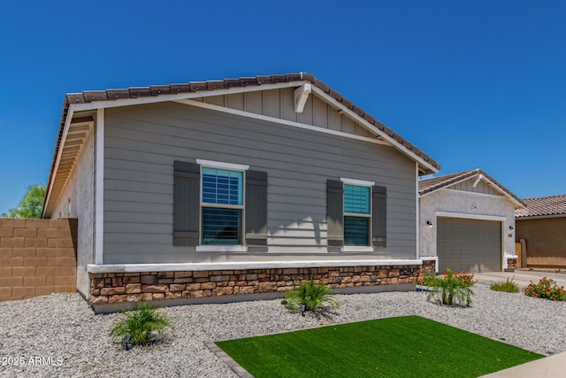 5314 N 182nd Ln, Litchfield Park, AZ 85340 - view of front of home with stone siding, a garage, a tiled roof, and driveway