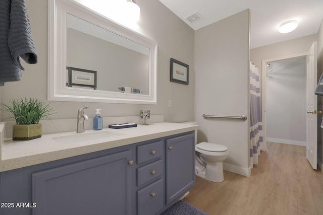 bathroom with hardwood / wood-style flooring, vanity, and toilet