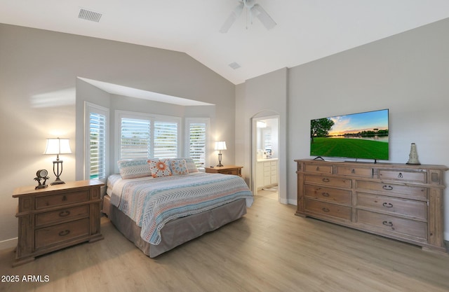 bedroom with lofted ceiling, ensuite bath, light hardwood / wood-style floors, and ceiling fan