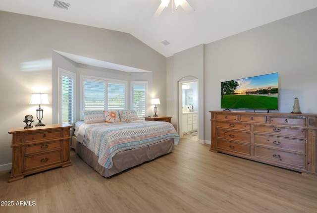 bedroom featuring connected bathroom, vaulted ceiling, ceiling fan, and light wood-type flooring