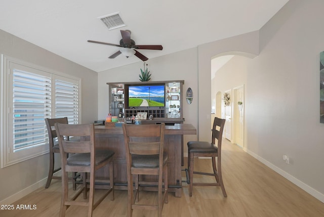 dining room with ceiling fan, lofted ceiling, and light wood-type flooring