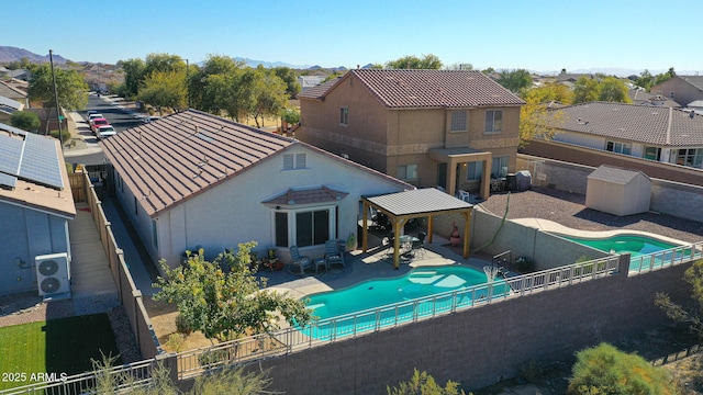 rear view of house with a patio, ac unit, central air condition unit, a fenced in pool, and a gazebo