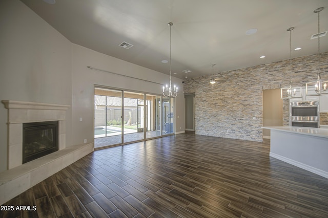 710 W Ardmore Rd, Phoenix, AZ 85041 - unfurnished living room with a fireplace, a chandelier, dark wood-style flooring, baseboards, and recessed lighting