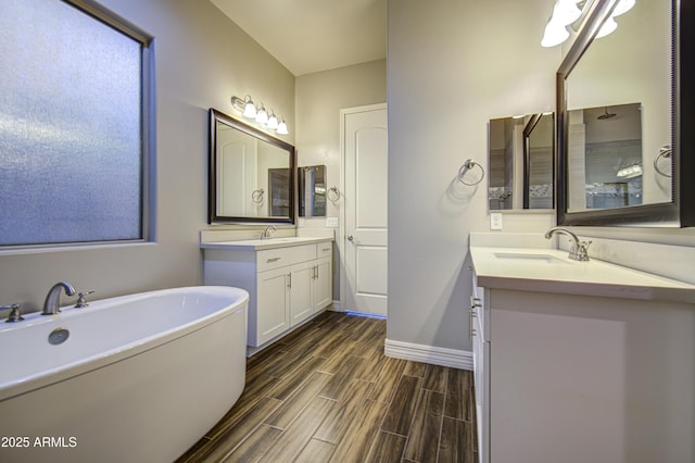 710 W Ardmore Rd, Phoenix, AZ 85041 - bathroom with a soaking tub, two vanities, baseboards, and wood finished floors