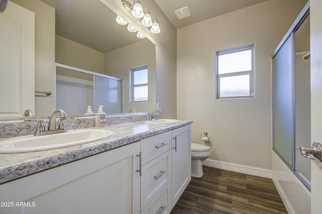 710 W Ardmore Rd, Phoenix, AZ 85041 - full bath with toilet, double vanity, combined bath / shower with glass door, baseboards, and wood finished floors