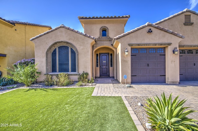 710 W Ardmore Rd, Phoenix, AZ 85041 - mediterranean / spanish-style home featuring stucco siding, a garage, decorative driveway, a front lawn, and a tile roof