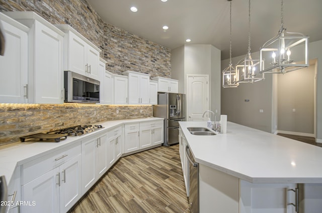 710 W Ardmore Rd, Phoenix, AZ 85041 - kitchen featuring appliances with stainless steel finishes, a sink, a chandelier, backsplash, and light countertops