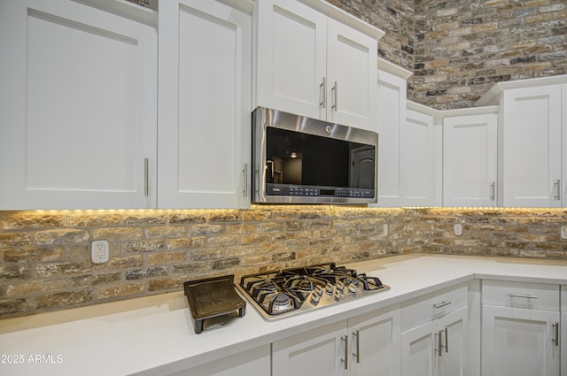 710 W Ardmore Rd, Phoenix, AZ 85041 - kitchen with stainless steel appliances, white cabinetry, decorative backsplash, and light countertops