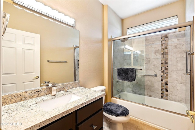 full bathroom featuring toilet, combined bath / shower with glass door, large vanity, and tile flooring