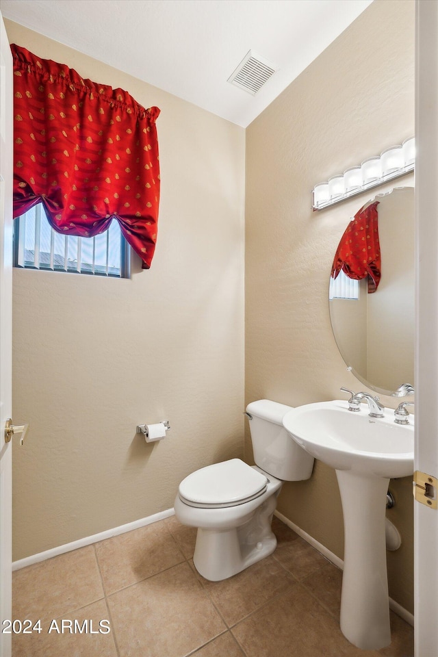 bathroom featuring tile flooring and toilet