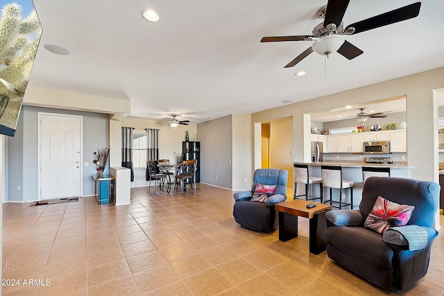 living area featuring ceiling fan and light tile floors