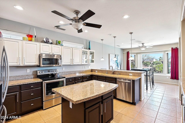 kitchen featuring white cabinets, appliances with stainless steel finishes, and a center island