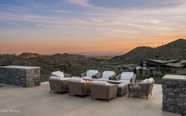 9643 E Cintarosa Pass, Scottsdale, AZ 85262 - patio terrace at dusk featuring a mountain view and an outdoor living space with a fire pit