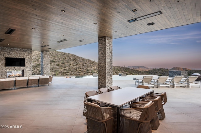 9643 E Cintarosa Pass, Scottsdale, AZ 85262 - view of patio featuring outdoor dining space, an outdoor living space with a fireplace, and a mountain view