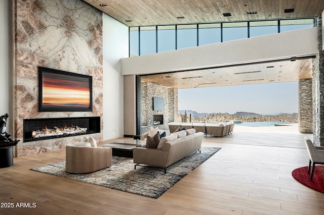 9643 E Cintarosa Pass, Scottsdale, AZ 85262 - living area featuring wood finished floors, a mountain view, a fireplace, and a towering ceiling