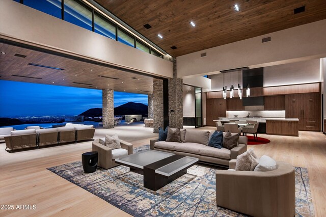 9643 E Cintarosa Pass, Scottsdale, AZ 85262 - living area with light wood-style flooring, decorative columns, wooden ceiling, and a high ceiling