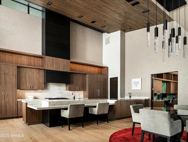 9643 E Cintarosa Pass, Scottsdale, AZ 85262 - kitchen featuring light countertops, light wood-style floors, wood ceiling, a towering ceiling, and extractor fan