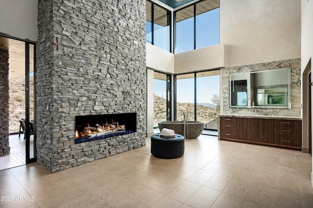 9643 E Cintarosa Pass, Scottsdale, AZ 85262 - living room with a high ceiling, light tile patterned floors, and a stone fireplace