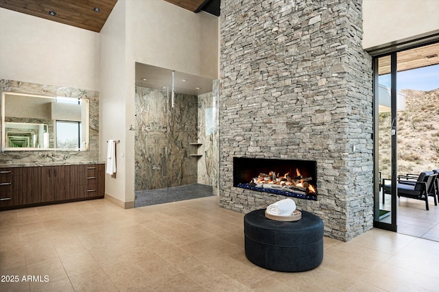 9643 E Cintarosa Pass, Scottsdale, AZ 85262 - full bath featuring vanity, a stone fireplace, tile patterned flooring, a high ceiling, and walk in shower
