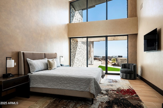 9643 E Cintarosa Pass, Scottsdale, AZ 85262 - bedroom featuring access to outside, multiple windows, baseboards, and wood finished floors
