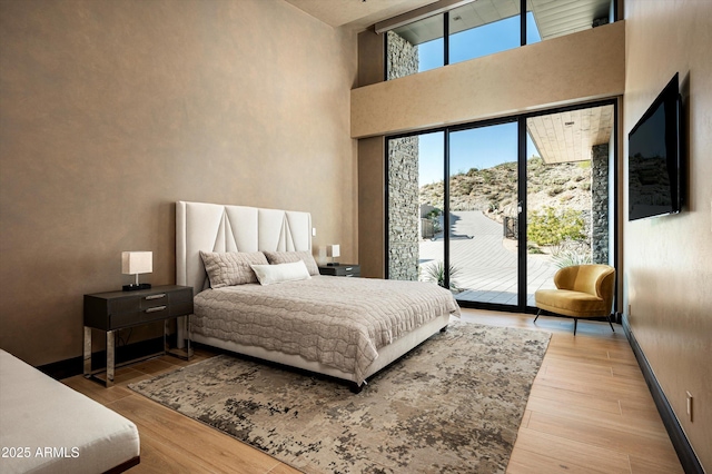 9643 E Cintarosa Pass, Scottsdale, AZ 85262 - bedroom with access to exterior, a high ceiling, wood finished floors, and baseboards