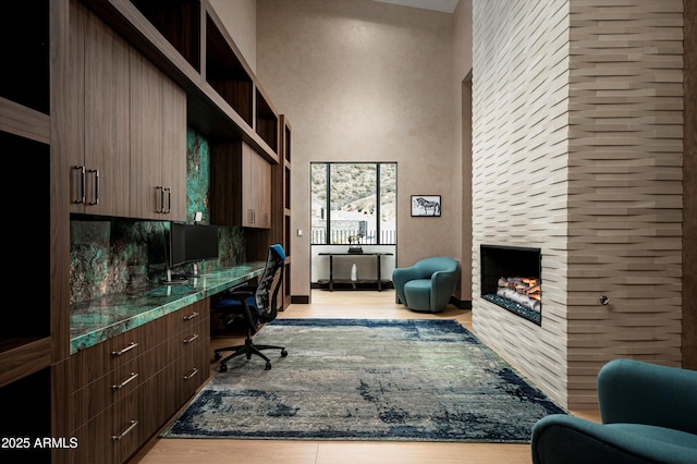 9643 E Cintarosa Pass, Scottsdale, AZ 85262 - home office featuring a large fireplace, light wood-style flooring, and built in study area