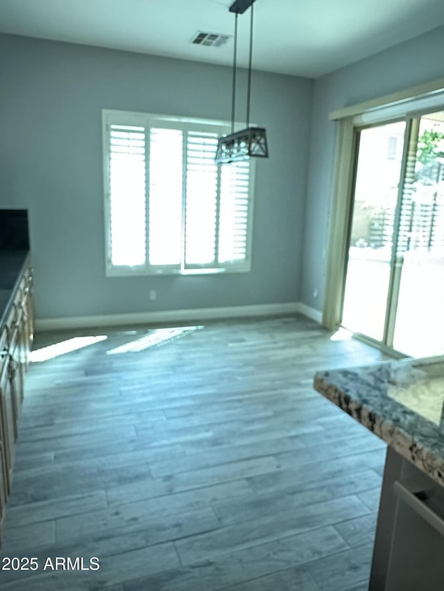 13259 W Flower St, Litchfield Park, AZ 85340 - unfurnished dining area featuring baseboards, visible vents, and wood finished floors