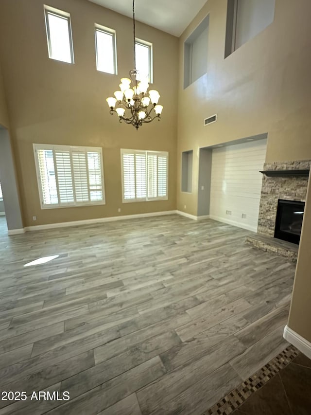 13259 W Flower St, Litchfield Park, AZ 85340 - unfurnished living room with an inviting chandelier, a towering ceiling, visible vents, and baseboards