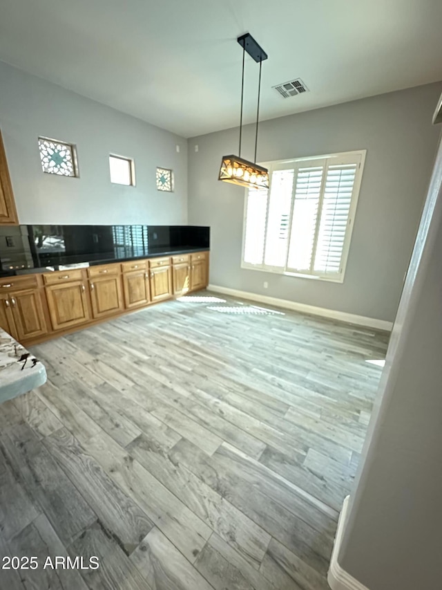 13259 W Flower St, Litchfield Park, AZ 85340 - kitchen with dark countertops, visible vents, baseboards, and light wood-style floors