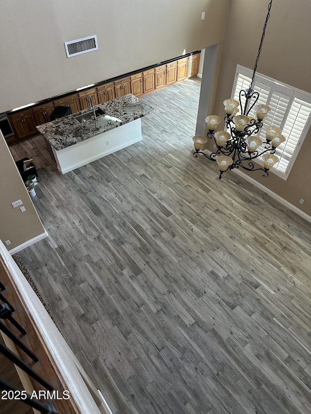 13259 W Flower St, Litchfield Park, AZ 85340 - interior space featuring visible vents, baseboards, an inviting chandelier, wood finished floors, and a high ceiling