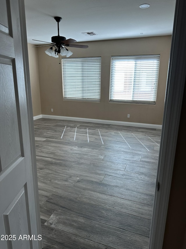 13259 W Flower St, Litchfield Park, AZ 85340 - spare room with visible vents, ceiling fan, wood finished floors, and baseboards