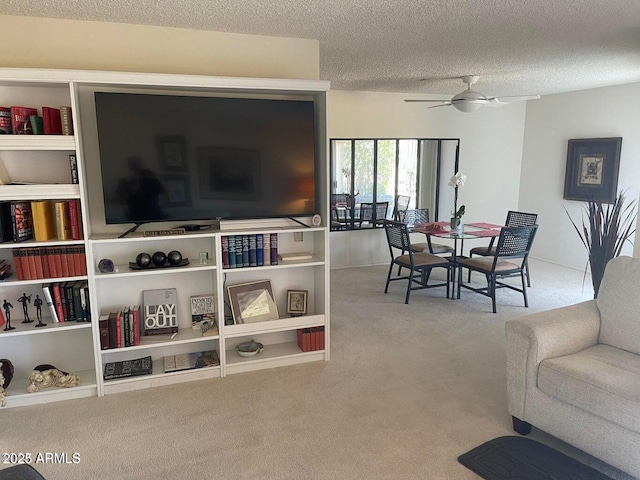 carpeted living room featuring ceiling fan and a textured ceiling